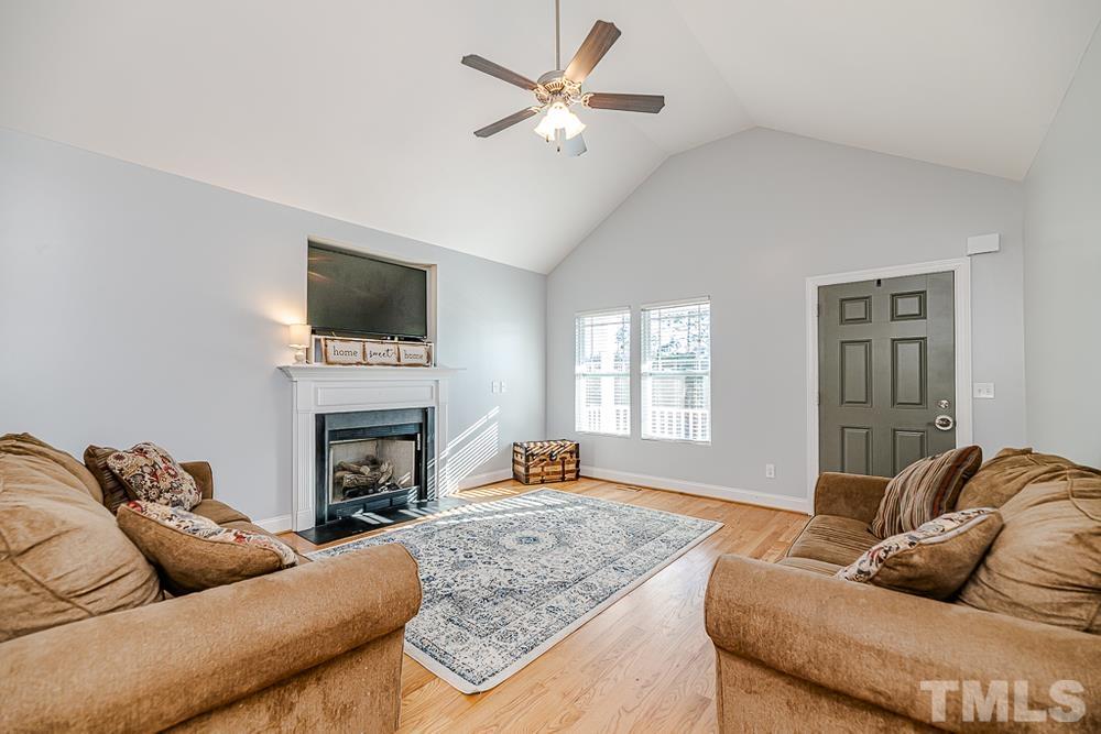 1652 Tingen Road Lillington, NC 27546 - Photo 6 of 30 a living room with furniture a fireplace and a flat screen tv