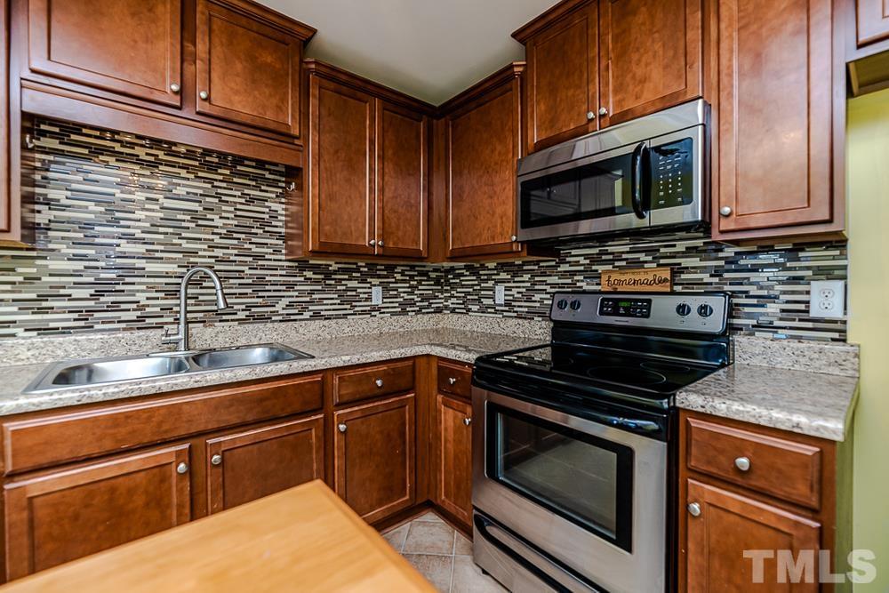 1652 Tingen Road Lillington, NC 27546 - Photo 10 of 30 a kitchen with stainless steel appliances granite countertop a sink stove and microwave