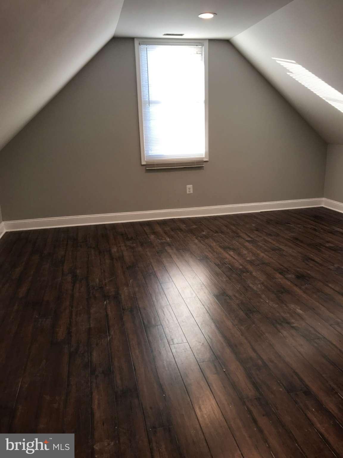3227 Grace Road Baltimore, MD 21219 - Photo 13 of 19 an empty room with wooden floor and windows