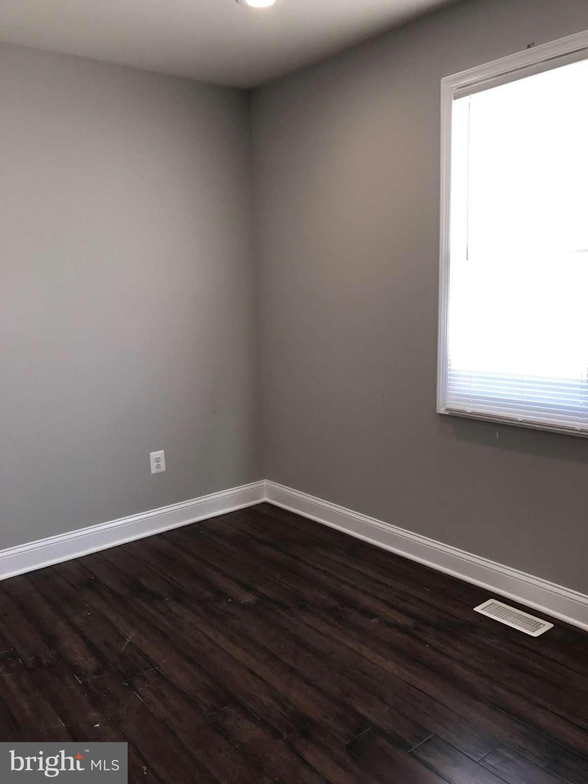 3227 Grace Road Baltimore, MD 21219 - Photo 7 of 19 a view of an empty room with wooden floor and a window
