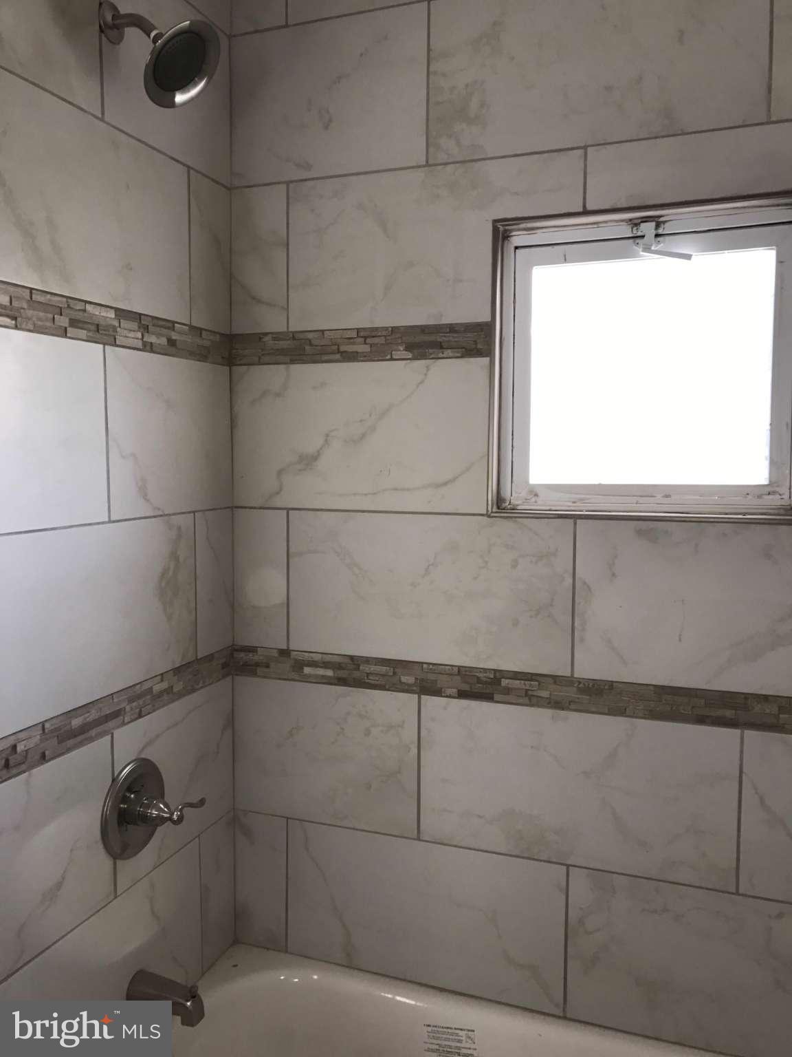 3227 Grace Road Baltimore, MD 21219 - Photo 8 of 19 a bathroom with a window and a shower