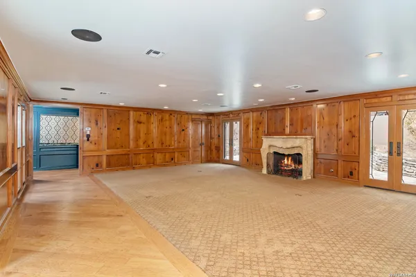 a view of an empty room with a fireplace and window