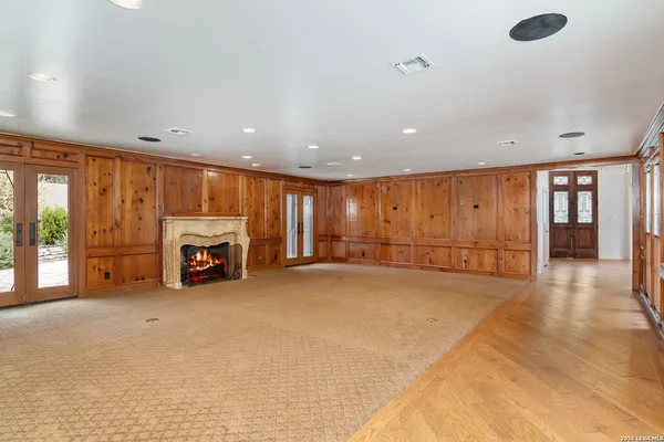 a view of an empty room with a fireplace and window