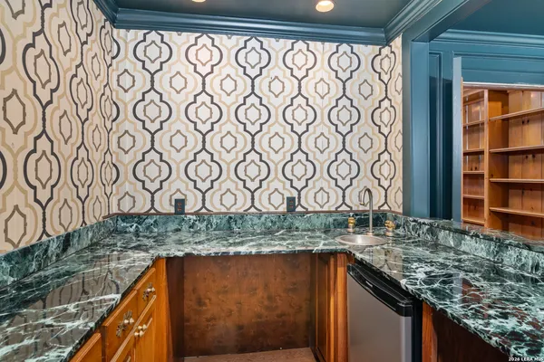 a kitchen with a granite countertop sink and cabinets