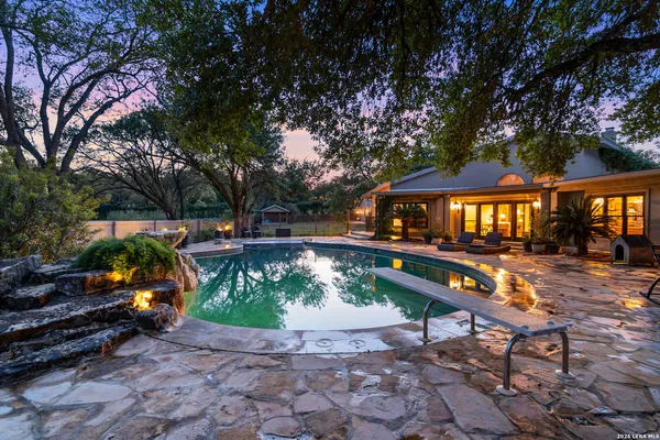 a backyard of a house with barbeque oven table and chairs
