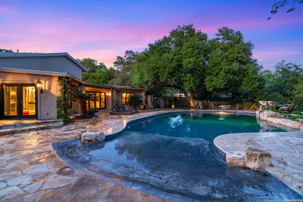 a view of a house with backyard and sitting area