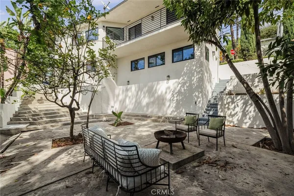 a view of backyard with table and chairs and a fire pit