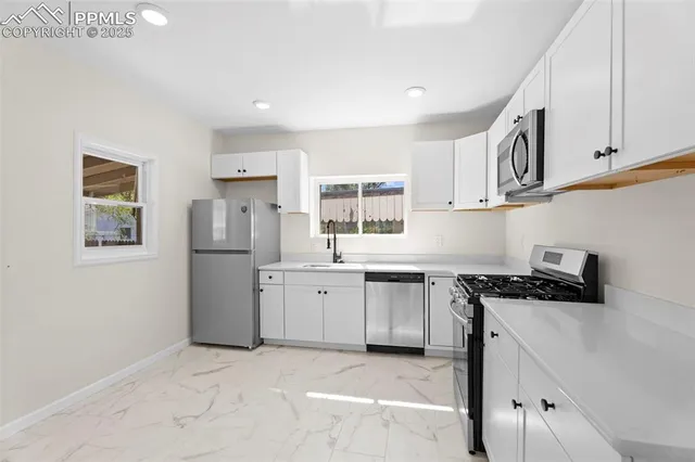 a kitchen with stainless steel appliances granite countertop a stove a sink and a refrigerator
