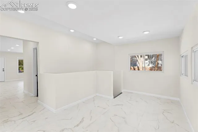 a large white kitchen with cabinets and a refrigerator