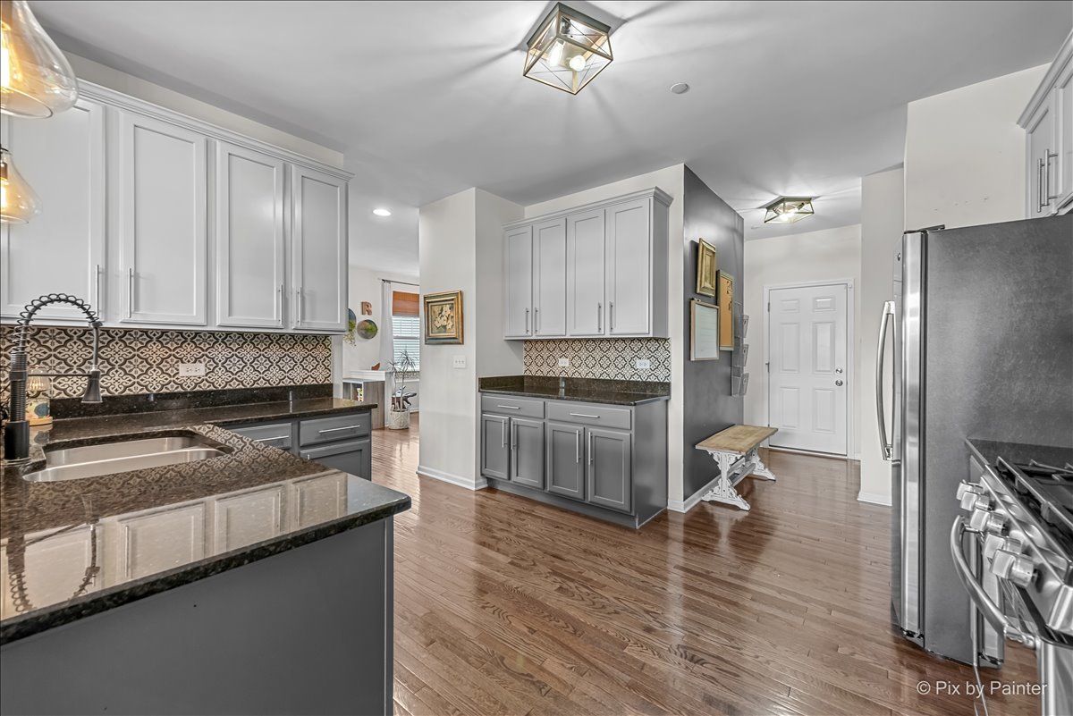 16207 West Switch Grass Road Lockport, IL 60441 - Photo 13 of 45 a kitchen with a refrigerator and a stove top oven