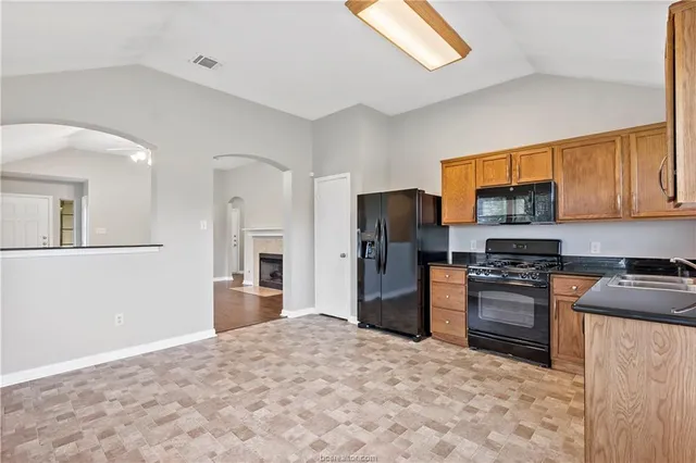 a kitchen with stainless steel appliances granite countertop a refrigerator stove top oven a sink and dishwasher