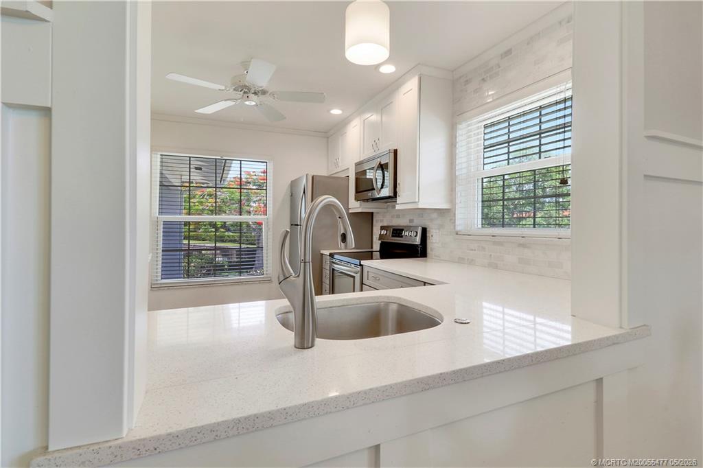 1852 Southwest Palm City Road, Unit 201 Stuart, FL 34994 - Photo 17 of 34 a kitchen with kitchen island a sink appliances and a counter top space