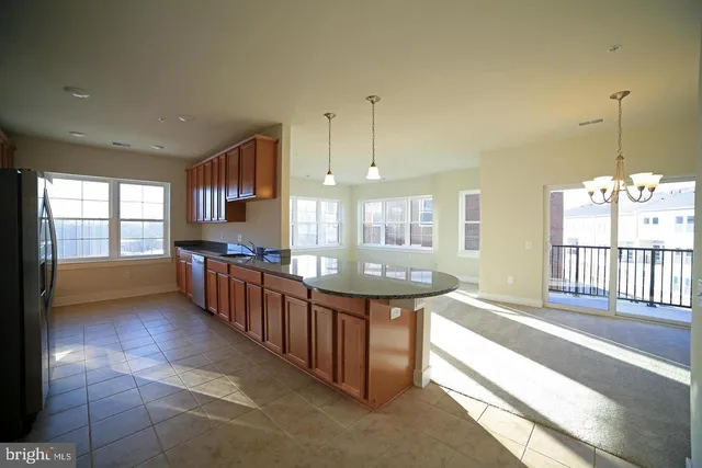 a large kitchen with kitchen island granite countertop a large window and a sink