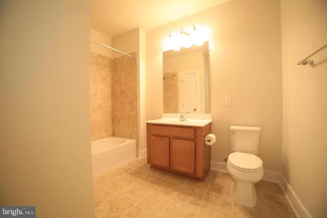 a bathroom with a granite countertop sink a toilet and a bathtub