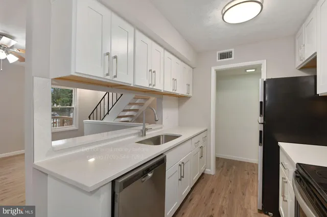 a kitchen with stainless steel appliances granite countertop a sink and a refrigerator