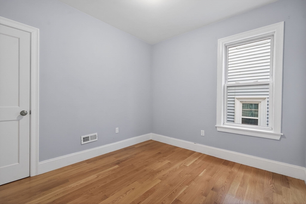 29 East Street, Unit 2 Boston, MA 02122 - Photo 8 of 15 a view of an empty room with wooden floor and a window