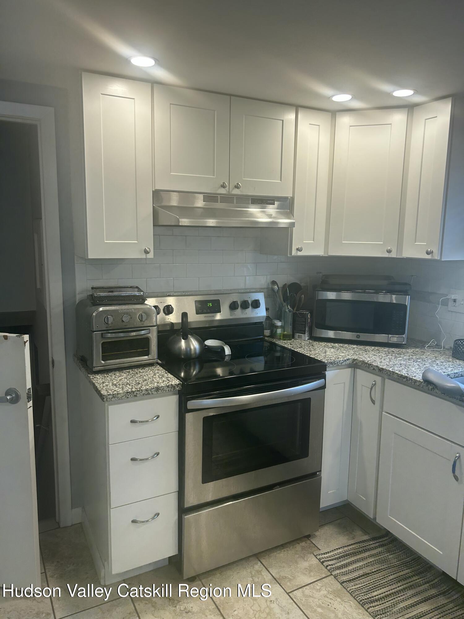 22 Caywood Road Poughkeepsie, NY 12603 - Photo 8 of 27 a kitchen with granite countertop a stove sink and cabinets