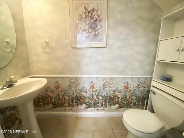 a bathroom with a sink a toilet and a mirror