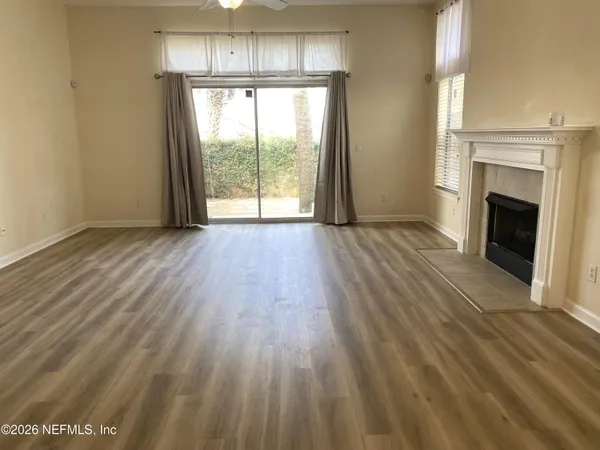 a view of empty room with wooden floor and fireplace