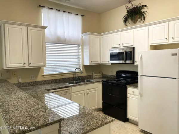 a kitchen with stainless steel appliances granite countertop a refrigerator stove microwave and sink