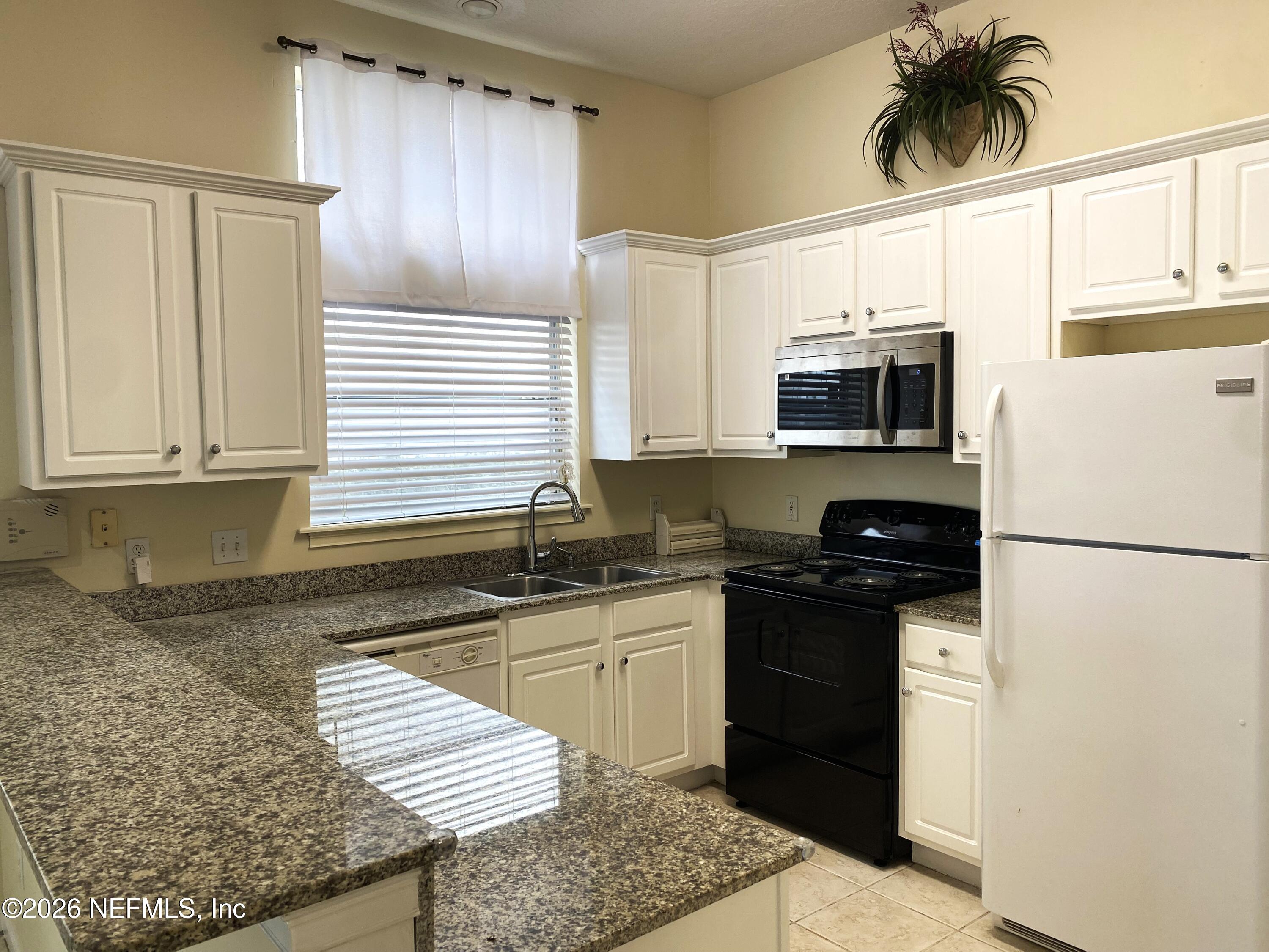 120 Seminole Road Atlantic Beach, FL 32233 - Photo 4 of 21 a kitchen with stainless steel appliances granite countertop a refrigerator stove microwave and sink