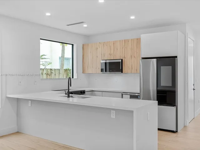 a kitchen with stainless steel appliances a sink a microwave a stove and a refrigerator