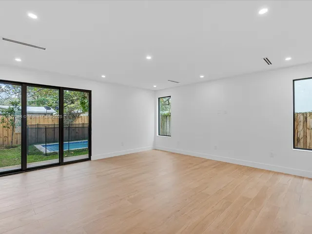an empty room with sliding glass door and mountain view