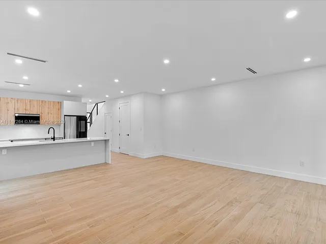 a view of kitchen with kitchen island and stainless steel appliances