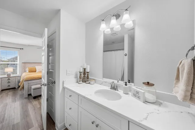 a bathroom with a sink a toilet a mirror a bathtub and shower