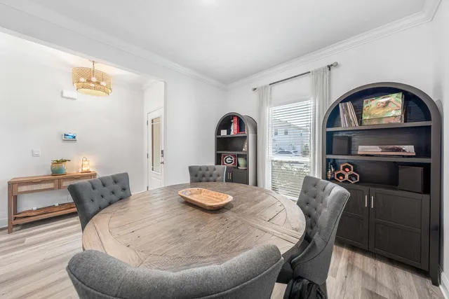 a kitchen with stainless steel appliances a dining table chairs and refrigerator