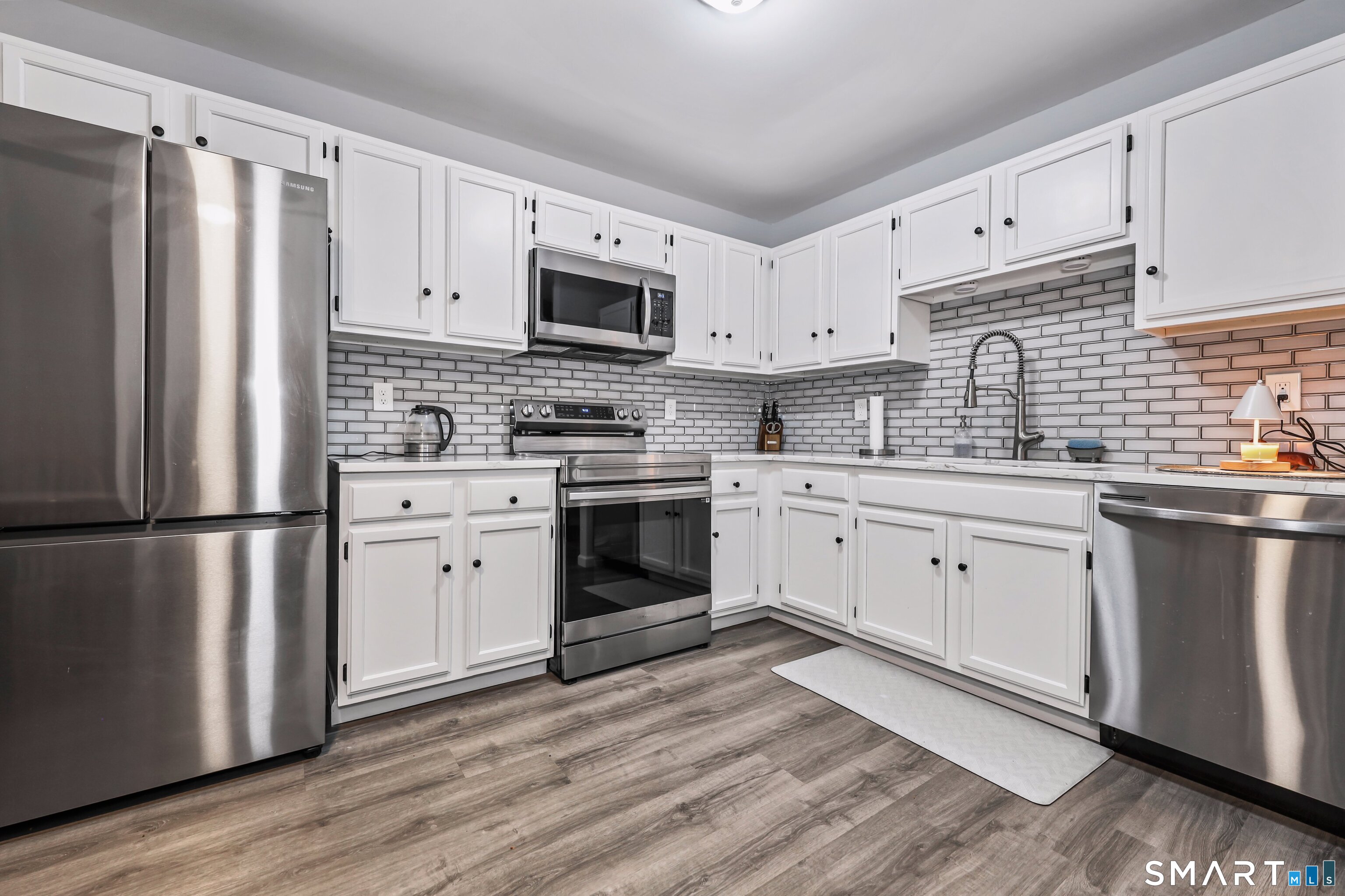143 Pine Hill Road, Unit 5C Thomaston, CT 06787 - Photo 6 of 29 a kitchen with white cabinets stainless steel appliances and sink