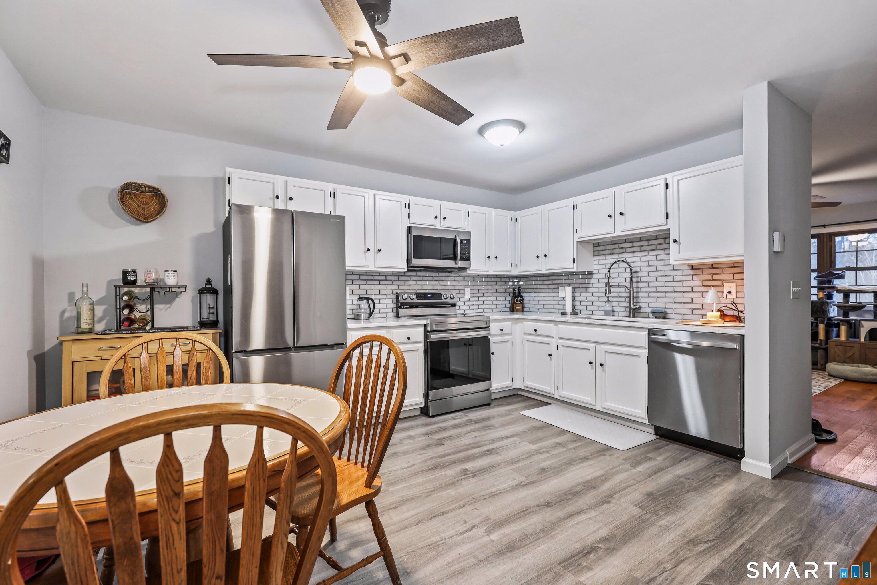 143 Pine Hill Road, Unit 5C Thomaston, CT 06787 - Photo 9 of 29 a kitchen with stainless steel appliances a stove a sink dishwasher a refrigerator with a dining table and chairs
