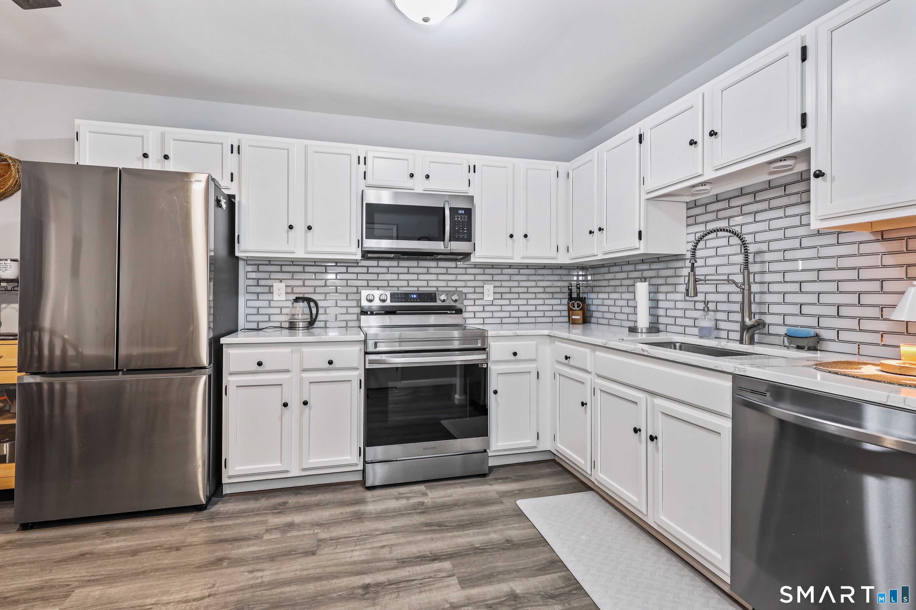 143 Pine Hill Road, Unit 5C Thomaston, CT 06787 - Photo 10 of 29 a kitchen with stainless steel appliances granite countertop a refrigerator stove a sink and white cabinets