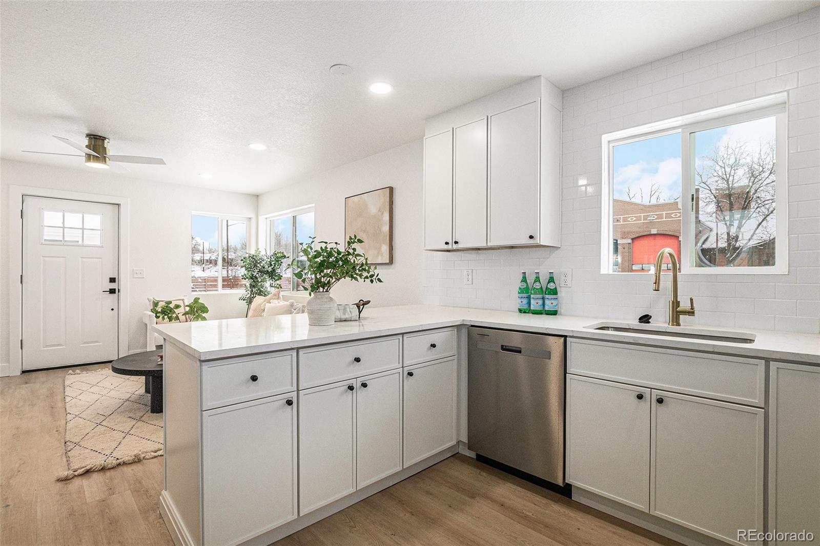 3211 Steele Street Denver, CO 80205 - Photo 11 of 26 a kitchen with white cabinets sink and window