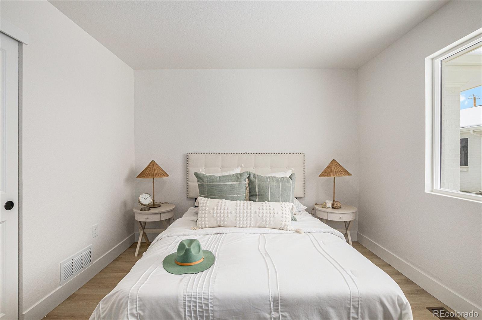 3211 Steele Street Denver, CO 80205 - Photo 15 of 26 a bedroom with a bed and wooden floor