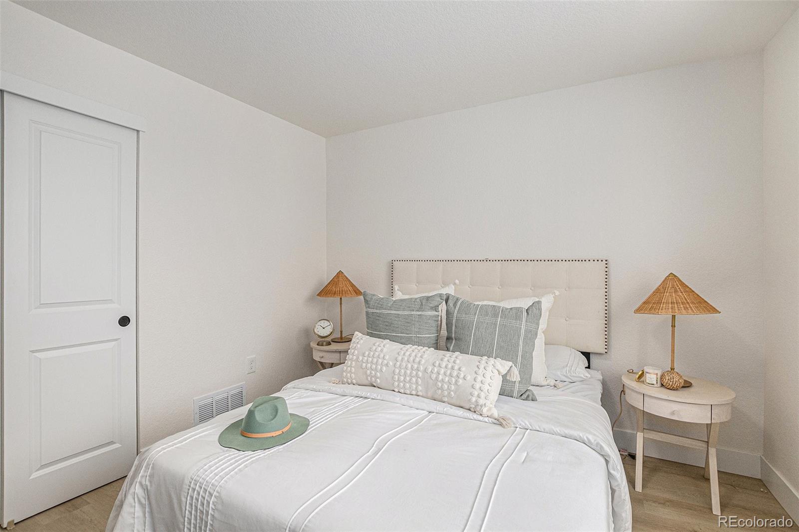 3211 Steele Street Denver, CO 80205 - Photo 16 of 26 a bedroom with a bed and a lamp