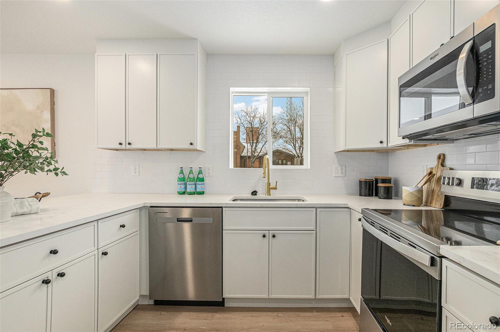 3211 Steele Street Denver, CO 80205 - Photo 9 of 26 a kitchen with white cabinets stainless steel appliances and sink