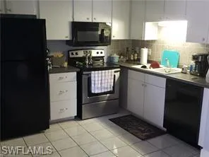 a kitchen with granite countertop a refrigerator and a stove top oven