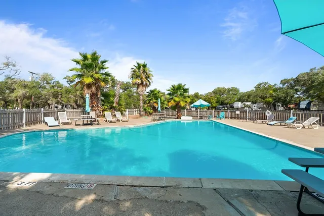 a view of a swimming pool with a lawn chairs and plants