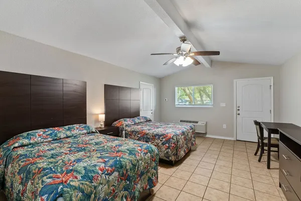 a bedroom with two bed and a television