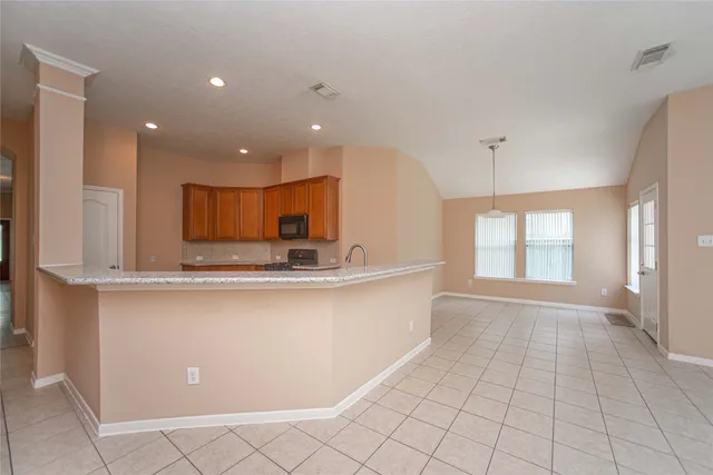 a large kitchen with stainless steel appliances a large counter top a sink and a window