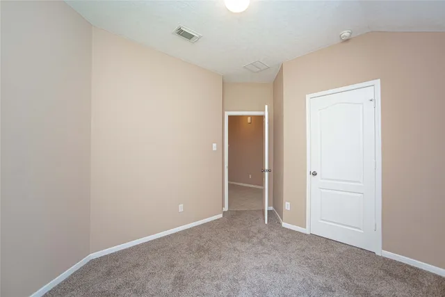 an empty room with closet and wooden door