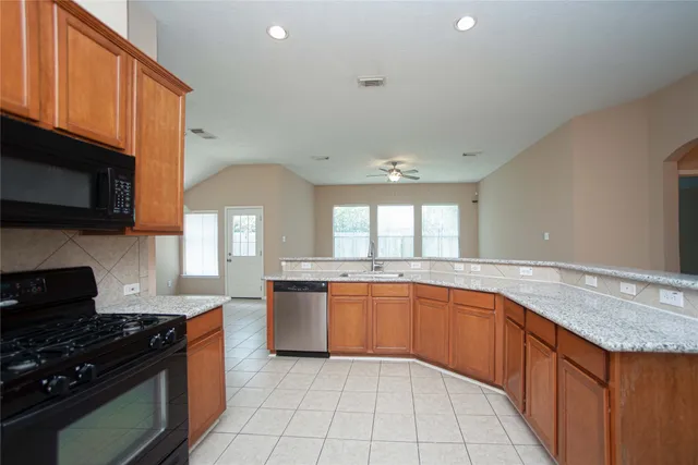 a large kitchen with stainless steel appliances granite countertop a sink and a stove