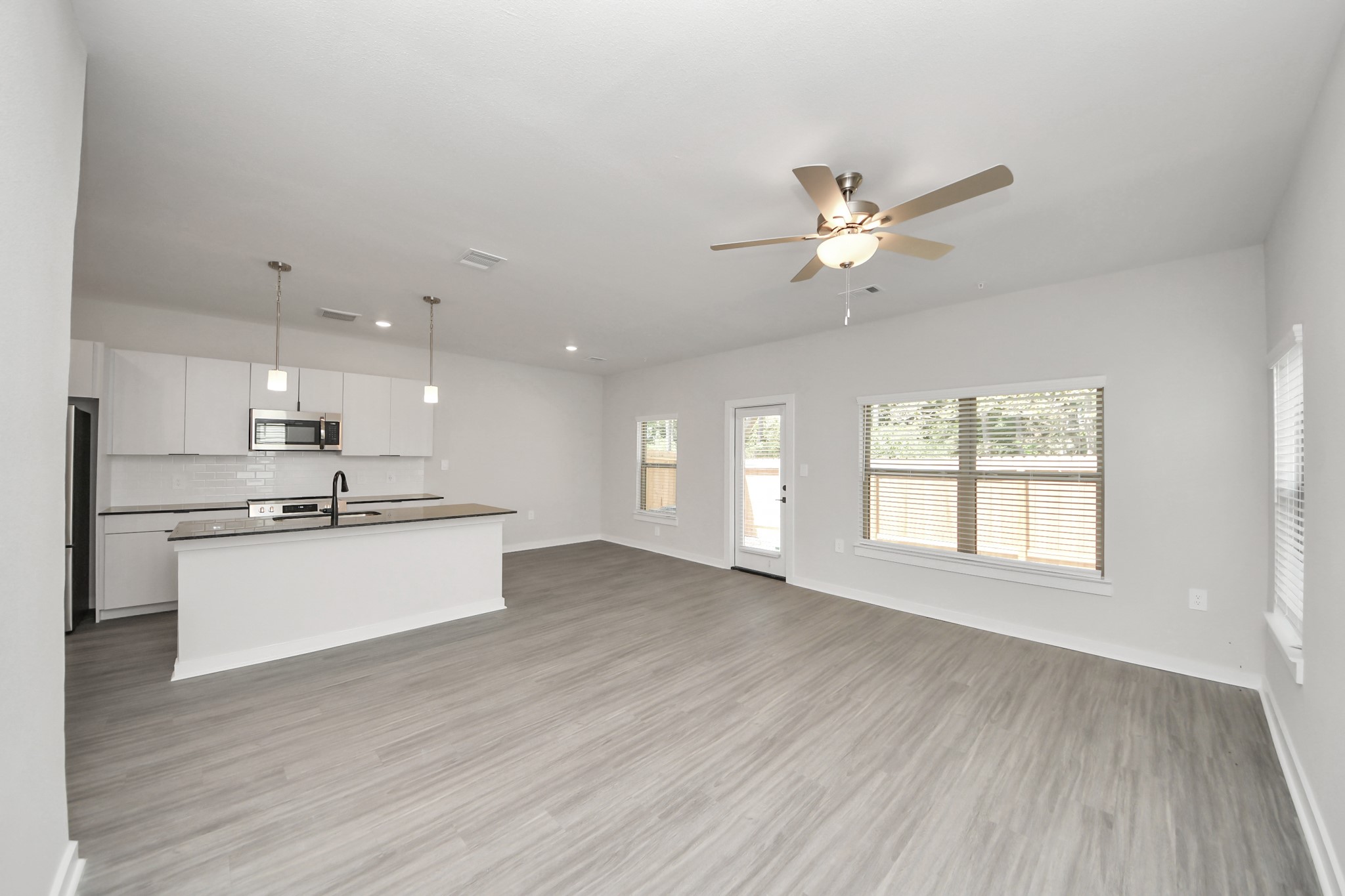 7711 Longmire Road, Unit 200 Conroe, TX 77304 - Photo 40 of 48 Boasting luxury finishes-stylish Island kitchen,granite counters,subway tile backsplash,ample custom cabinet space,stainless appliances,refrigerator,full size washer&dryer included,wood-like floors throughout,open concept floor plan.