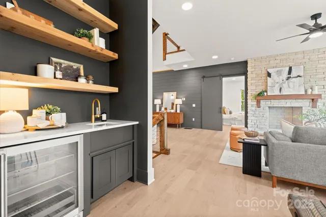 a living room with furniture a fireplace and a large window