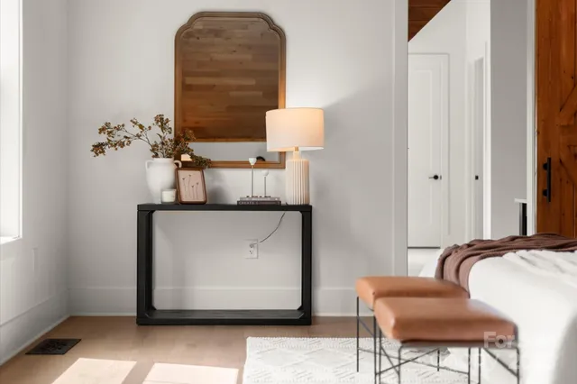 a spacious bedroom with a large bed a chandelier and windows