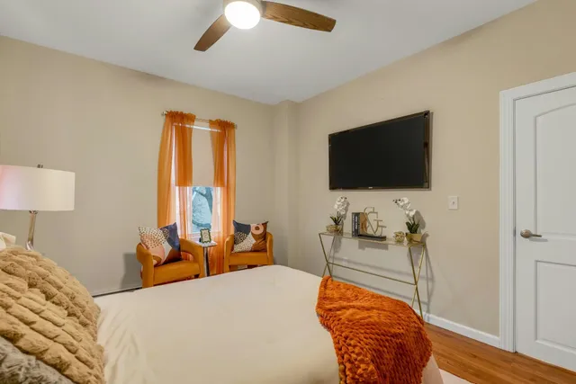a bedroom with a bed and a flat tv screen on dresser