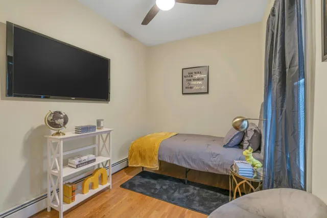 a bedroom with a bed and a flat tv screen on the dresser