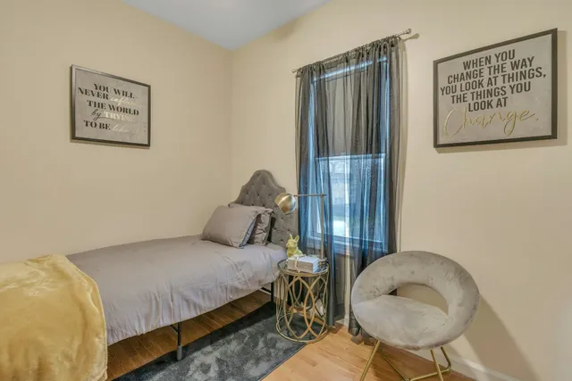 a bedroom with a bed and a painting on the wall