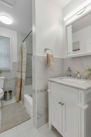 a bathroom with a granite countertop sink a toilet and shower